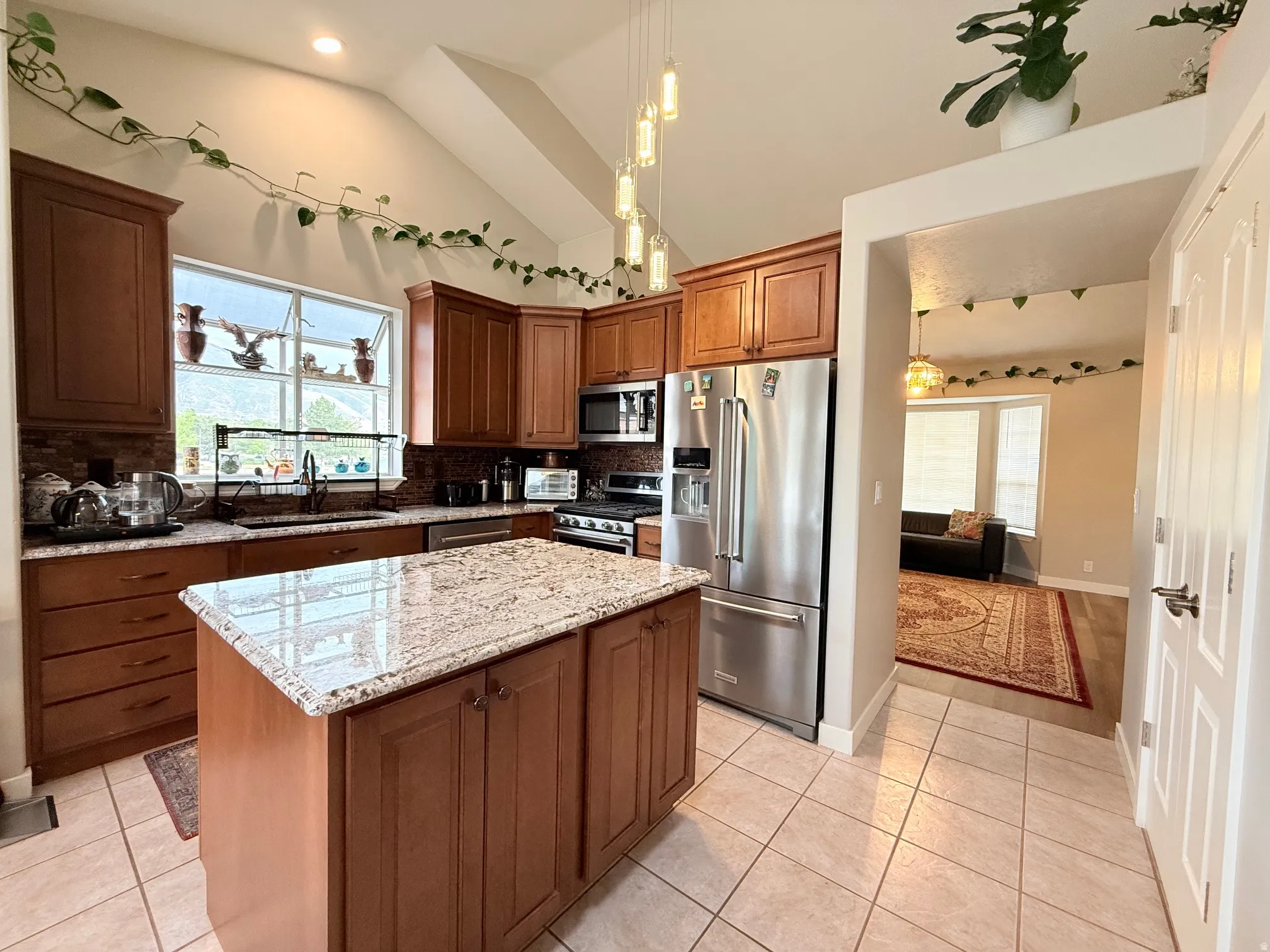 Kitchen featuring a central island with a granite countertop, wood cabinetry, and stainless steel appliances