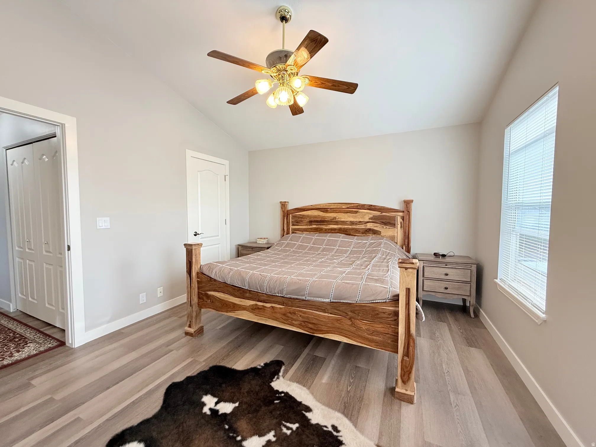 Vaulted ceiling room with wood-finish flooring