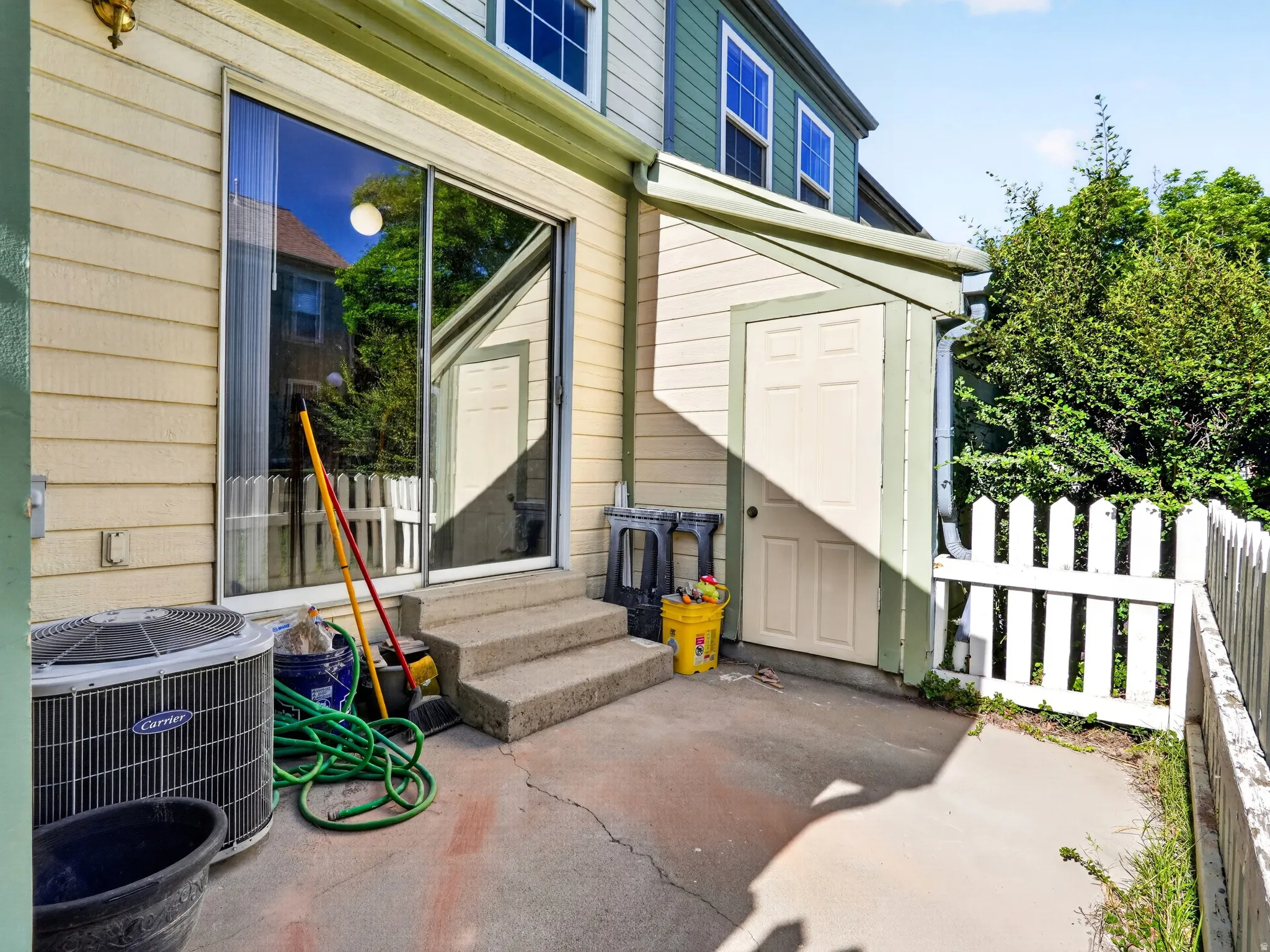 Rear patio with concrete surface and three-step entry