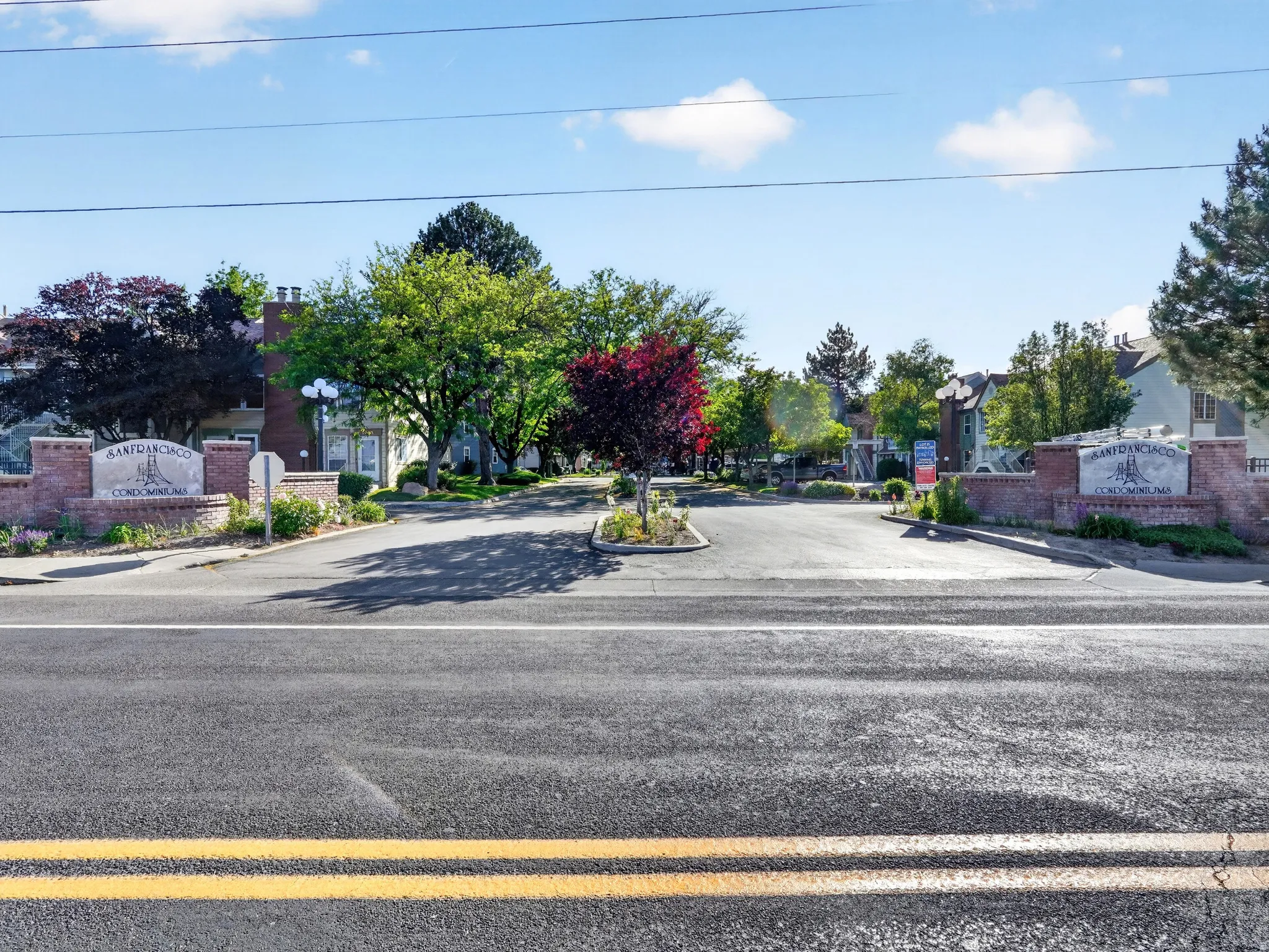 Community entrance featuring dual brick monument signs with integrated landscaping