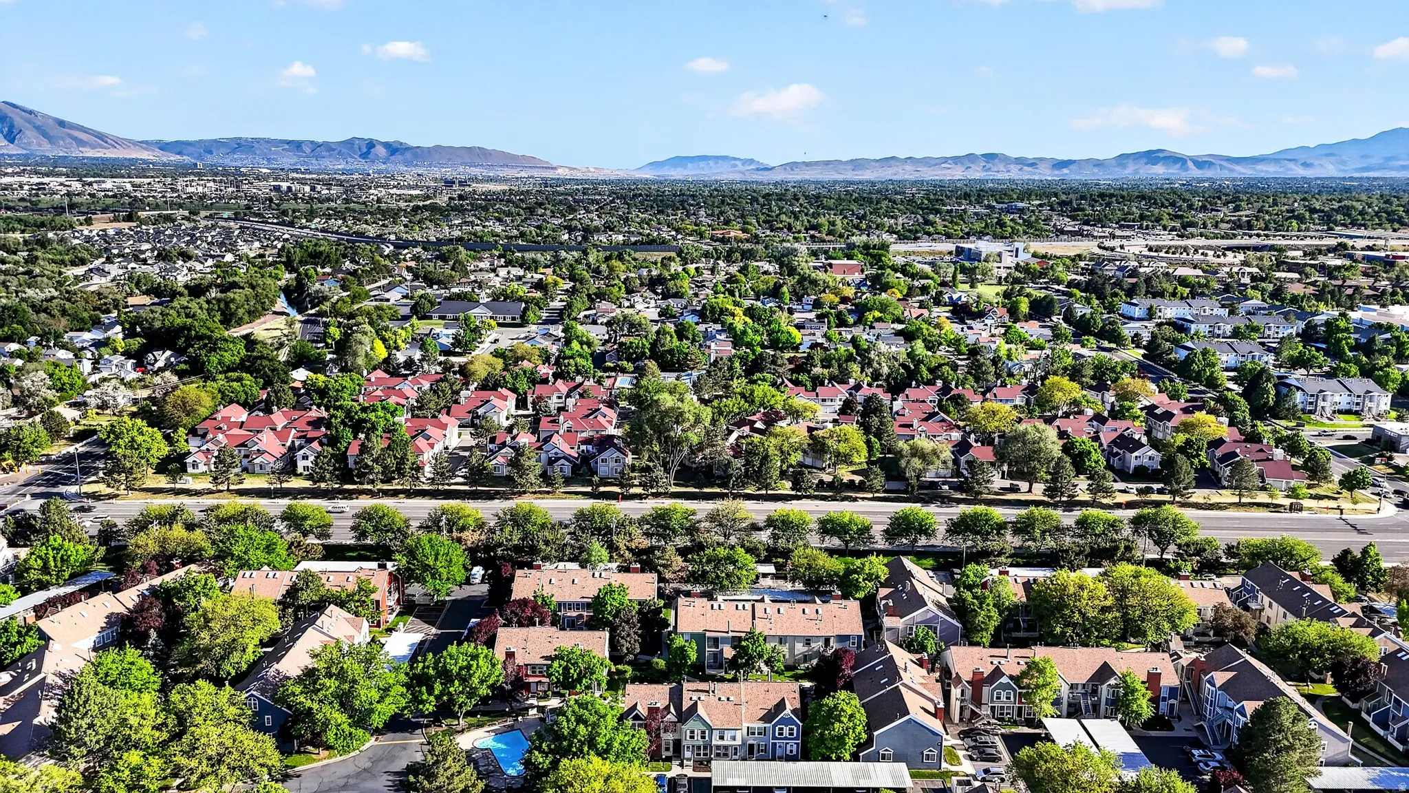 Expansive aerial perspective showcasing a residential development with varied rooflines and extensive tree canopy