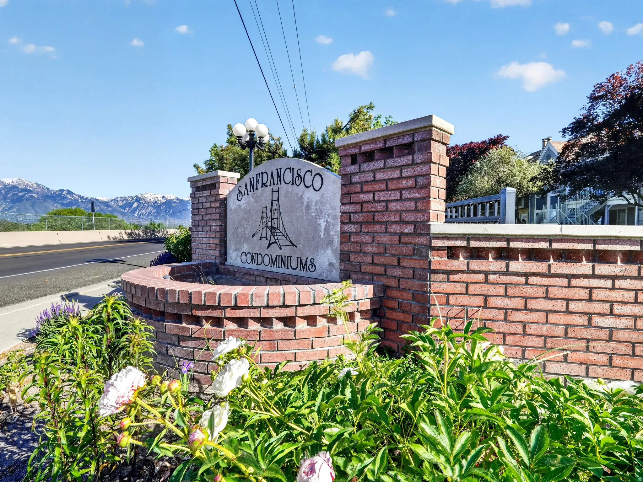Brick entry monument featuring a stone sign with "San Francisco Condominiums" inscription