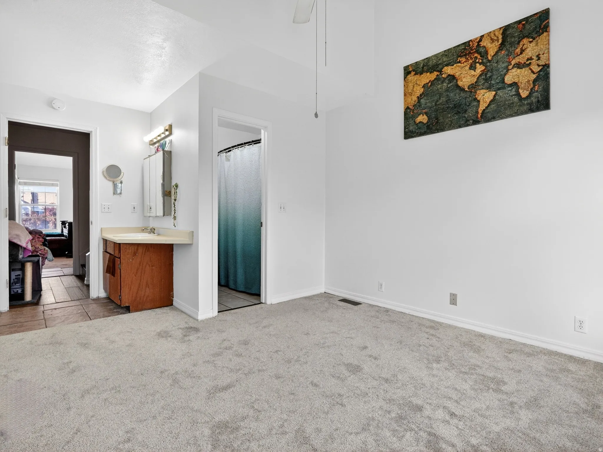 Spacious room featuring light-toned carpeting and vaulted ceilings