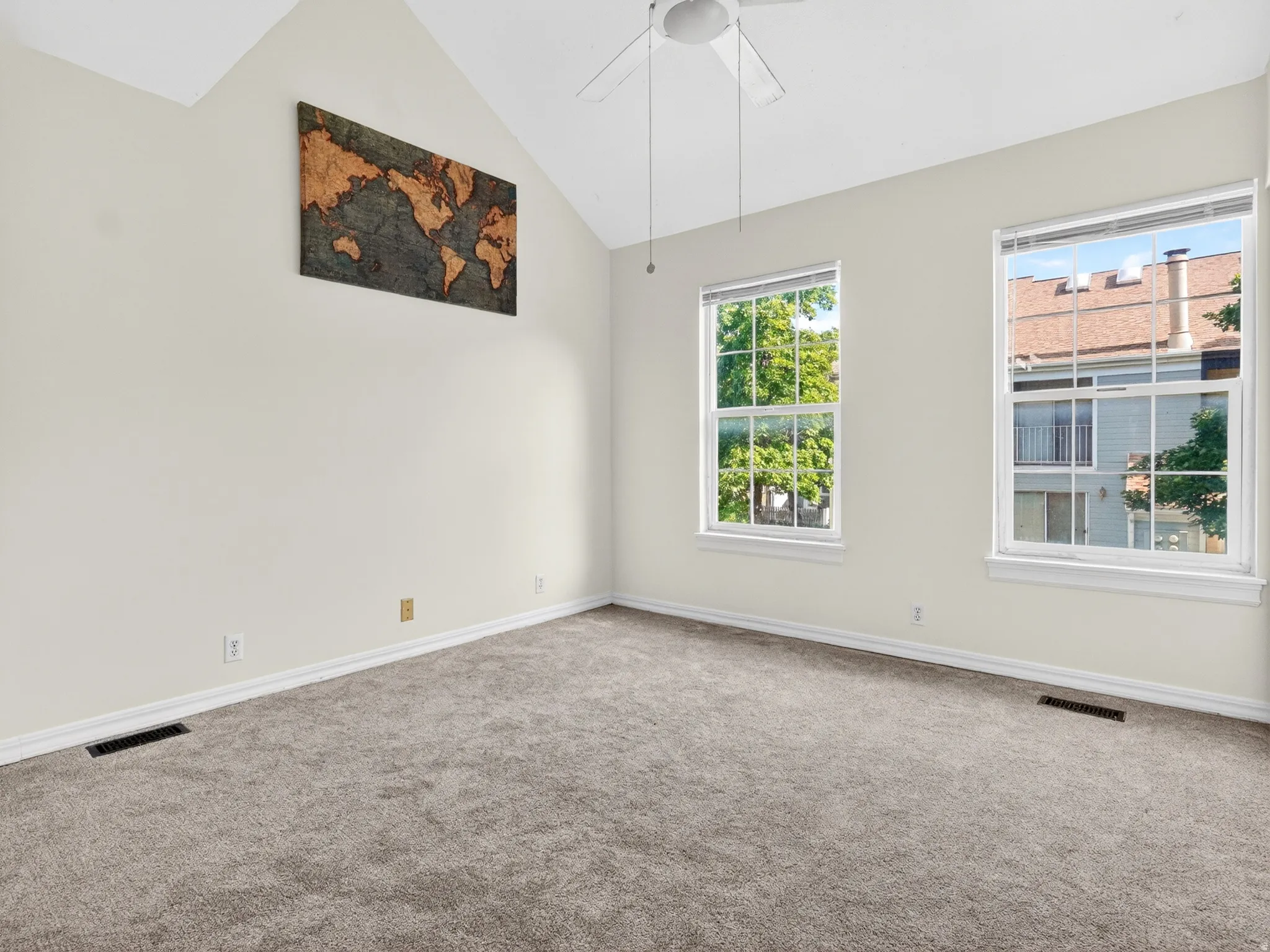 Room featuring vaulted ceilings and neutral-toned carpeting