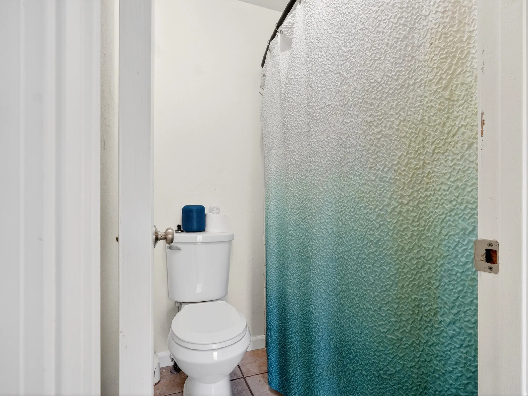 Bathroom featuring a white toilet, tile flooring, and a shower area