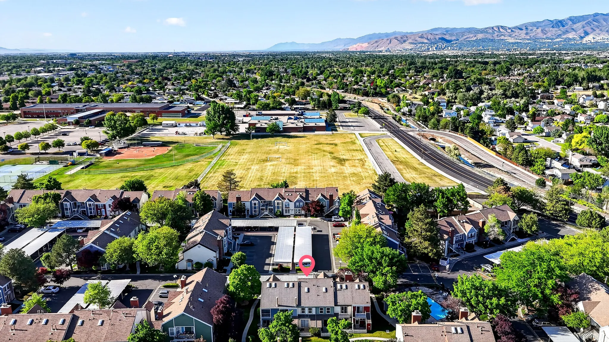 Aerial perspective showcasing the property within a residential community with abundant green spaces