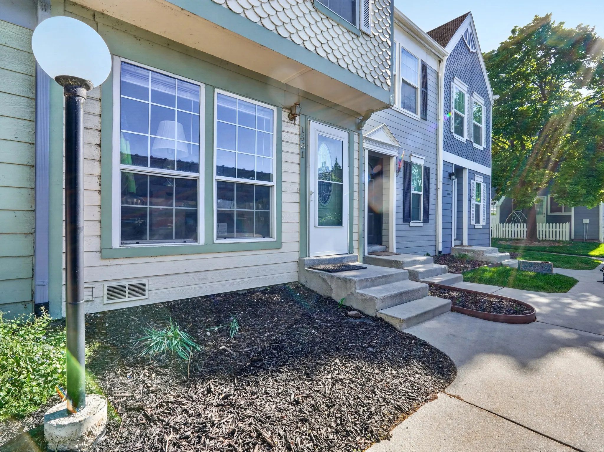 Two-story exterior featuring scalloped siding accents and multiple windows with grids