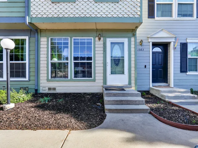Entrance featuring concrete steps and a white door with decorative glass