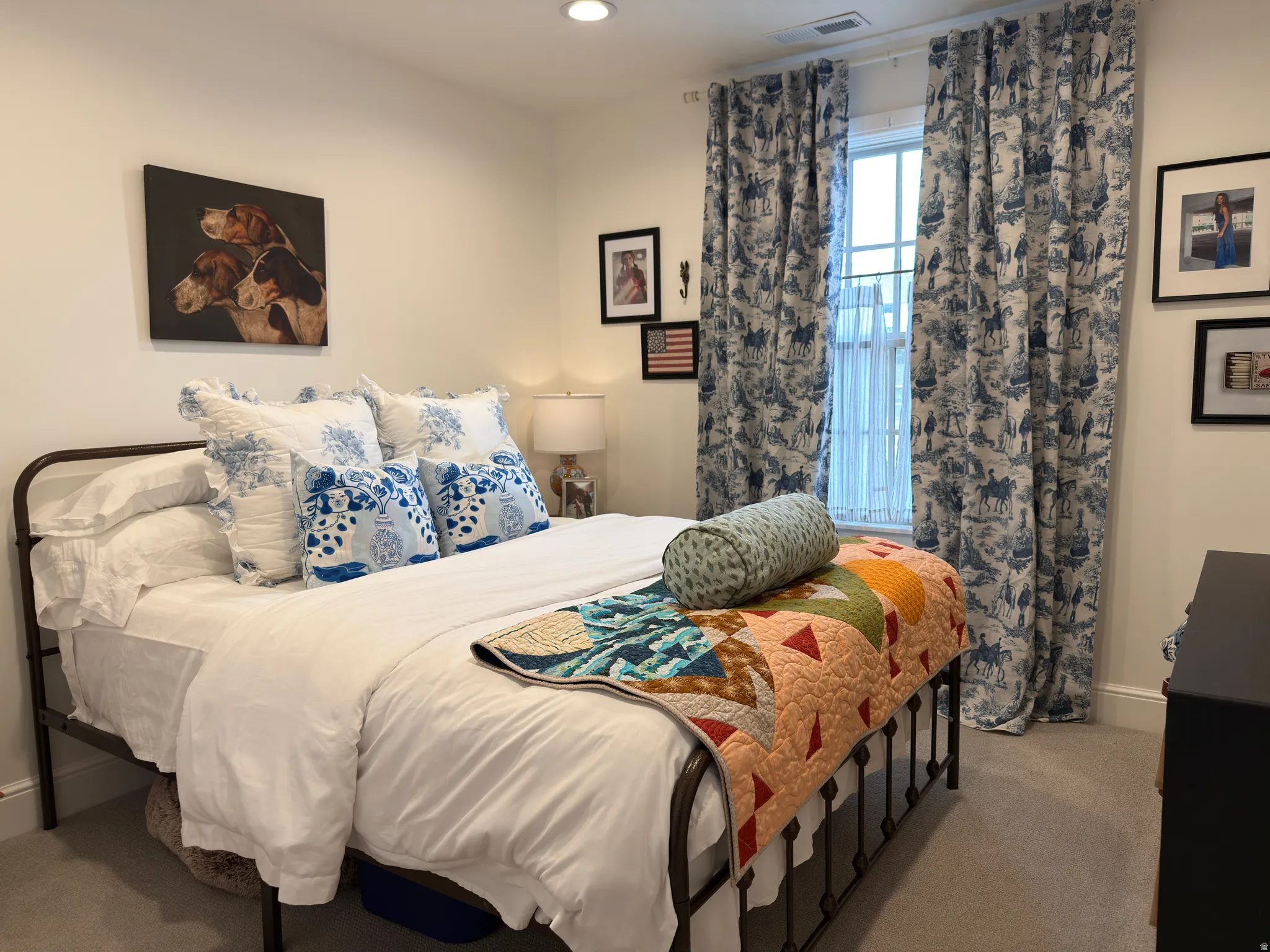Carpeted bedroom featuring recessed lighting and a window with patterned drapes