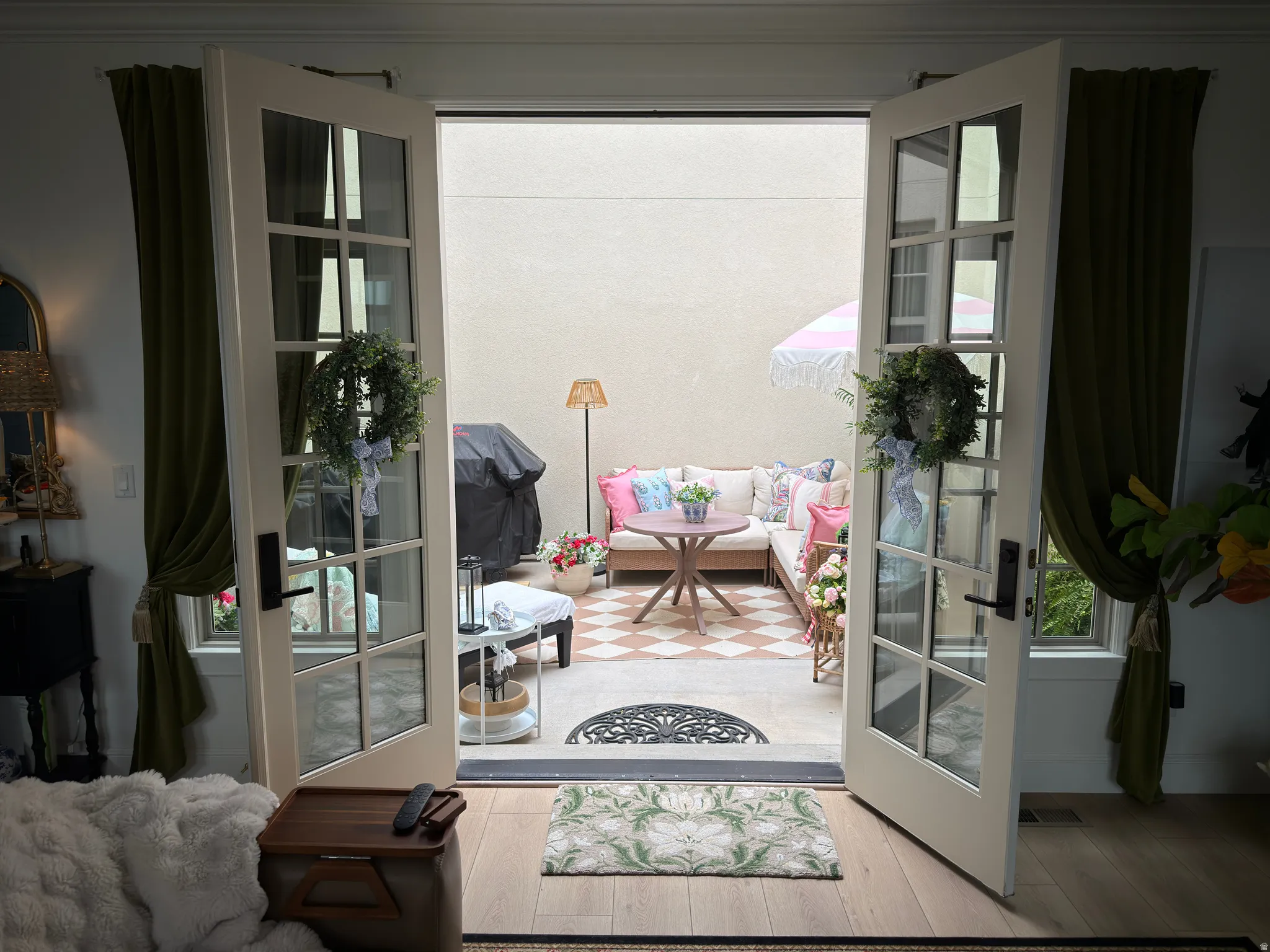 Private outdoor patio featuring checkerboard-patterned flooring, solid perimeter walls, and an exterior wall lantern