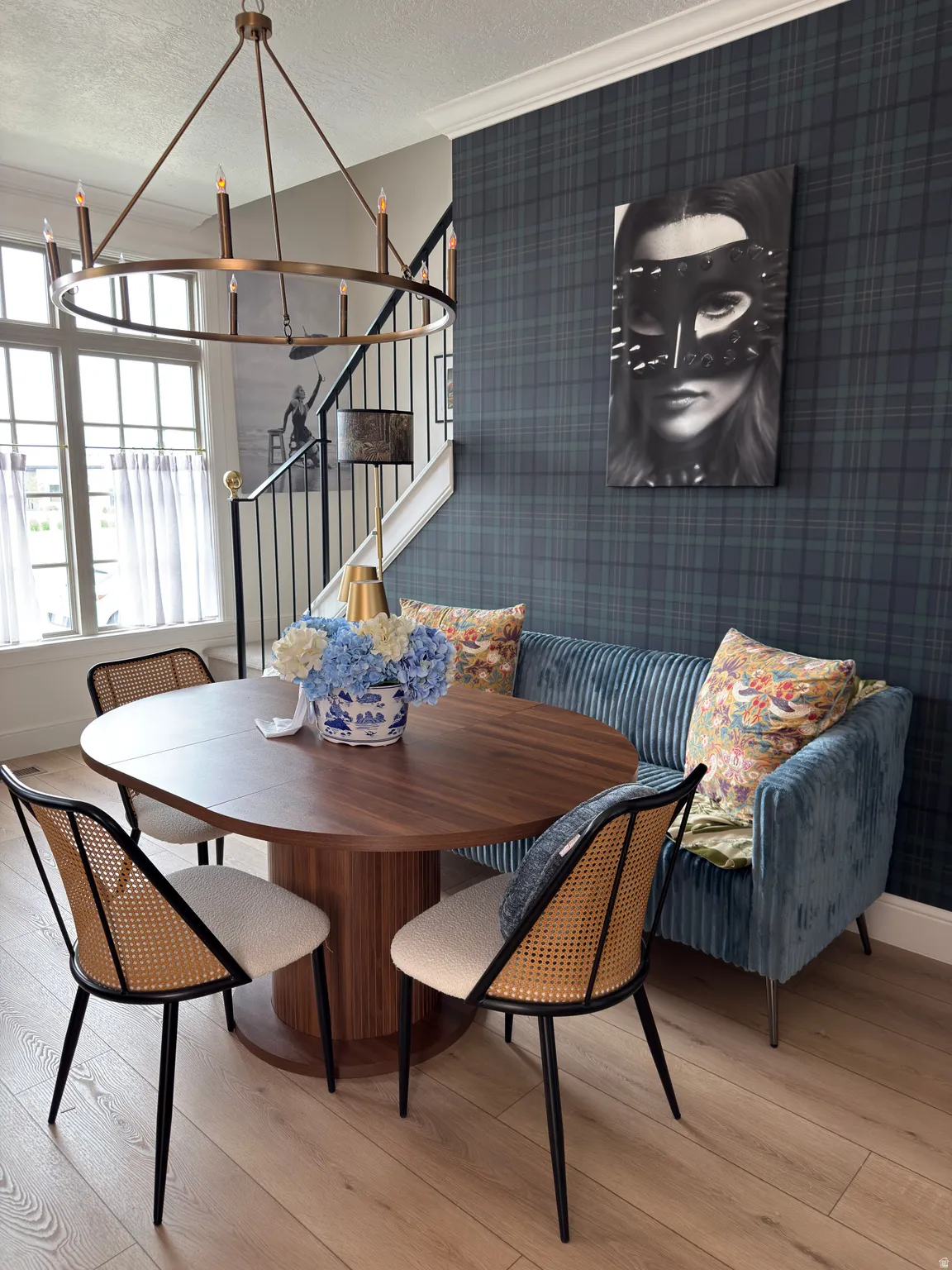 Dining area featuring wood-finish flooring, a circular bronze chandelier, and a built-in upholstered bench