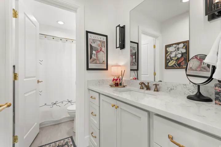 Bathroom vanity featuring a light-toned countertop, integrated sink, and bronze-finish faucet