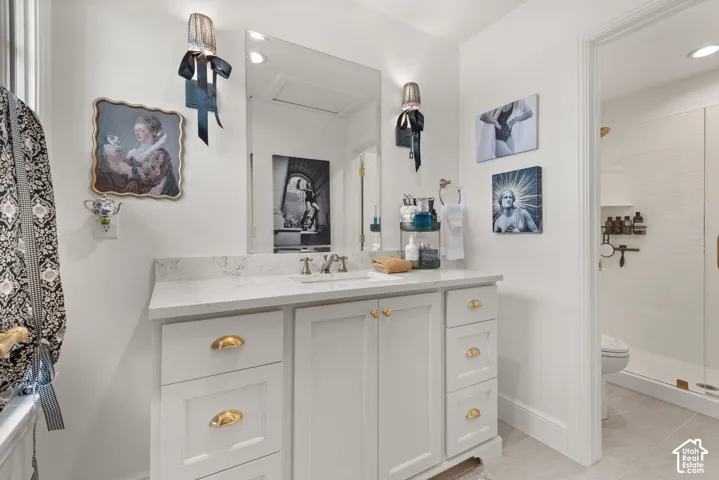 Master bathroom featuring a single vanity with stone countertop, an undermount sink, and brushed nickel faucet