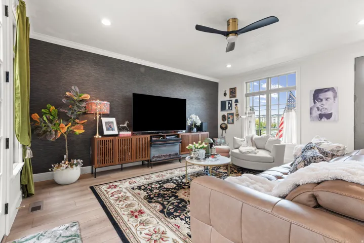 Living area featuring a textured accent wall and light wood-finish flooring