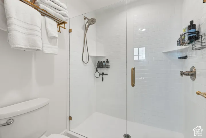Walk-in shower with clear glass enclosure and brushed brass hardware