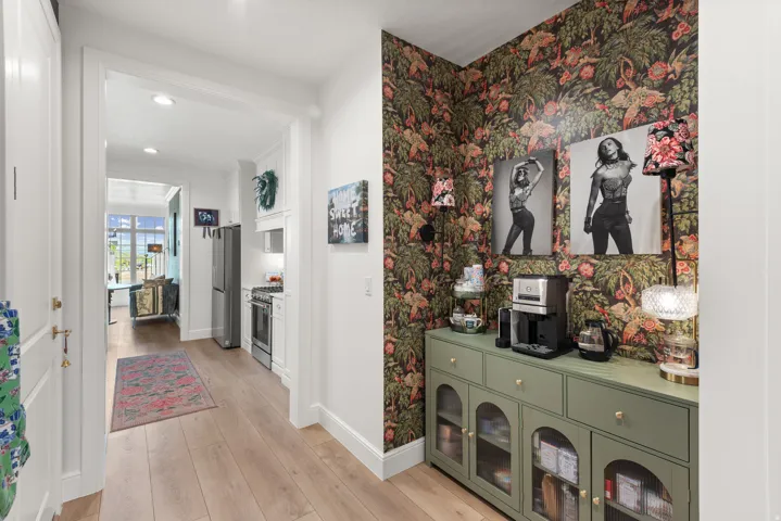 Hallway featuring wood-finish flooring, white trim and a beautiful coffee bar.