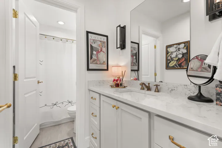 Bathroom vanity featuring a light-toned countertop, integrated sink, and bronze-finish faucet