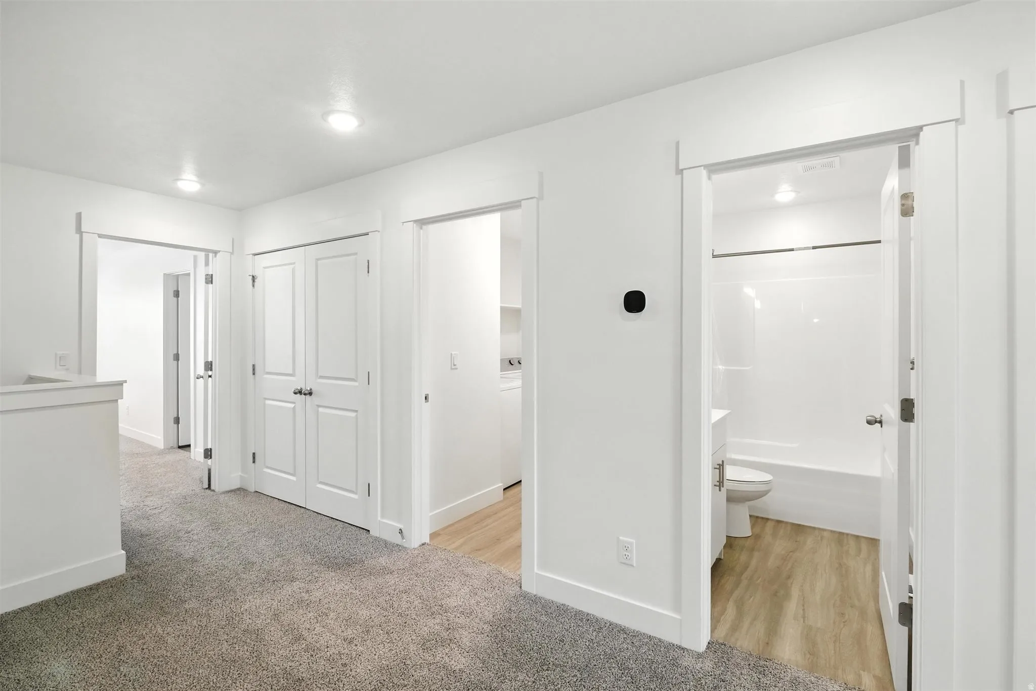 Open hallway featuring plush carpet flooring, recessed lighting, white trim, and white paneled doors