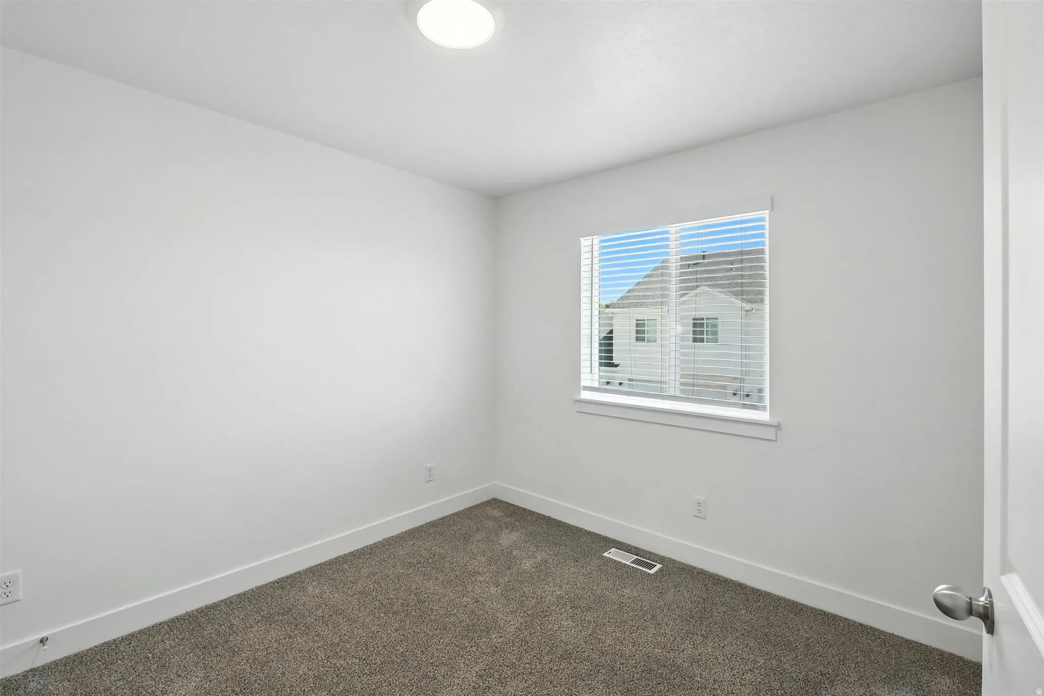Neutral wall paint in a matte finish, recessed ceiling lighting, textured carpeting, white window trim, and baseboard molding