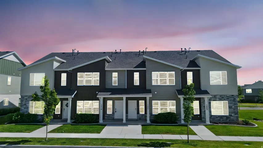 Modern multi-unit residence featuring a stone veneer facade, dark shingle roofing, and contemporary siding