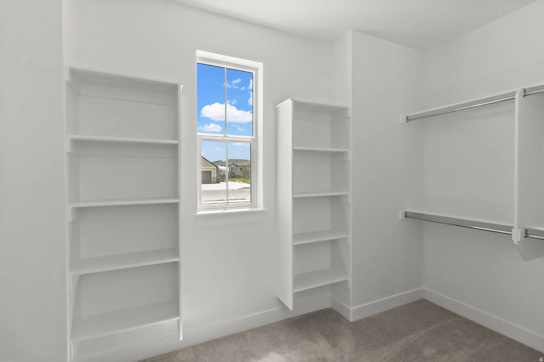 Primary Suite walk in Closet w/ lots of shelving, hanging space & natural light.