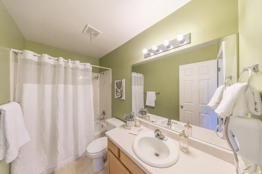 Hallway bathroom with full vanity, large mirror, full bath tub.