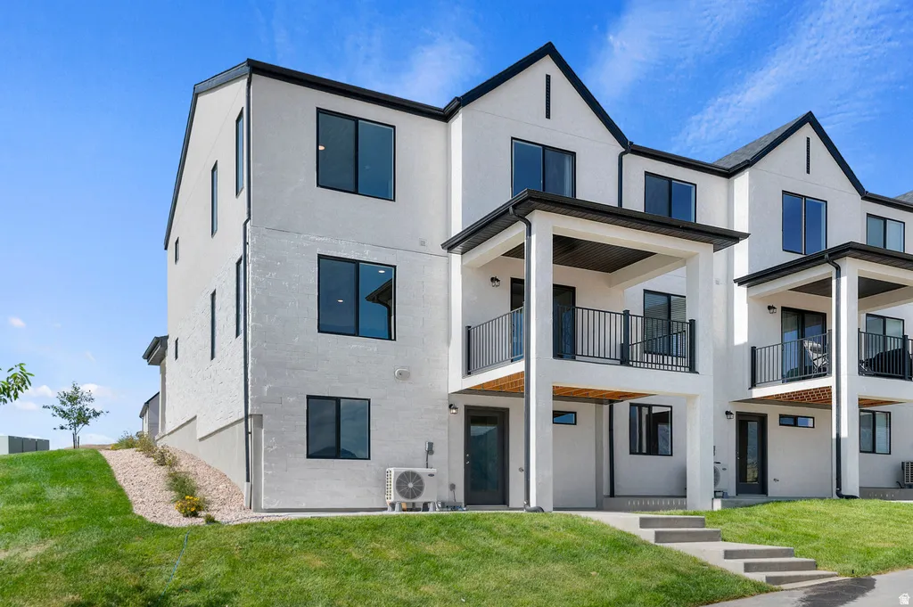 Modern white exterior with dark trim and multiple balconies