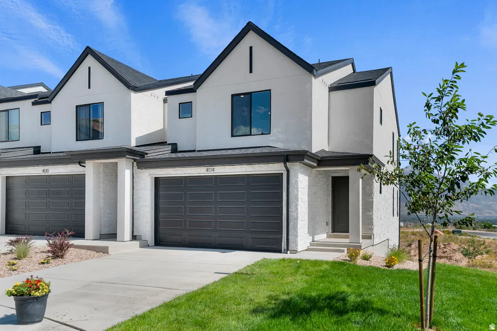 Modern stucco exterior with black-framed windows and a dark shingle roof