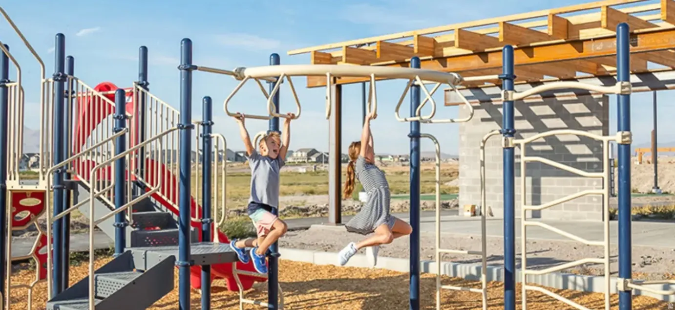 Outdoor playground featuring a multi-level structure with slides, climbing elements, and monkey bars