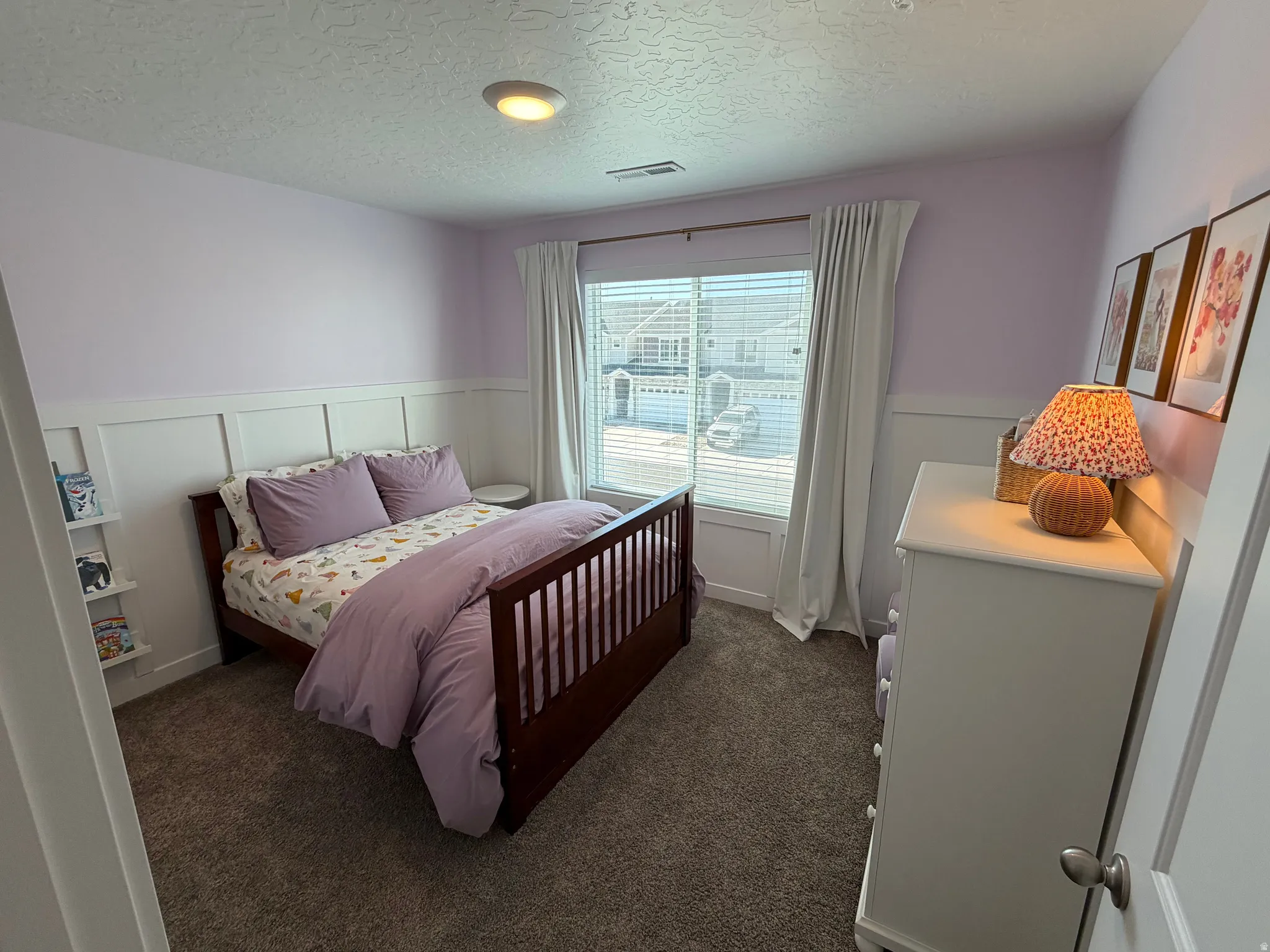 Carpeted room with board and batten wainscoting, single window with blinds, and flush mount ceiling light fixture
