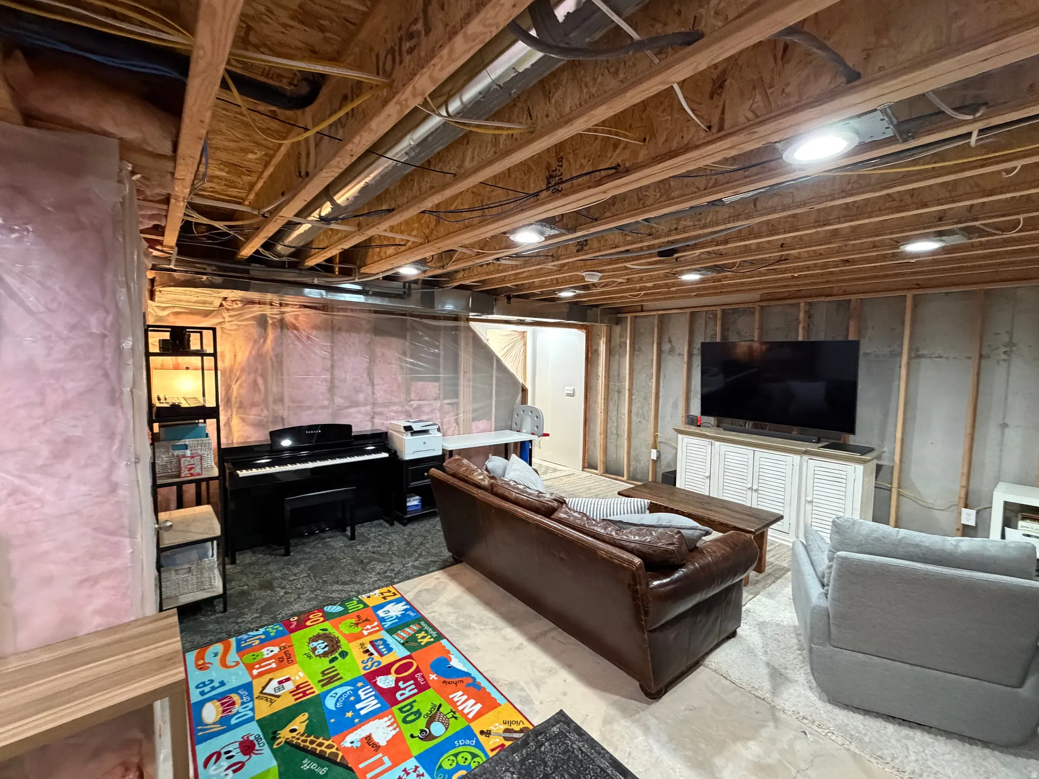 Unfinished lower level featuring exposed ceiling joists, recessed lighting, concrete flooring, and insulated framed walls