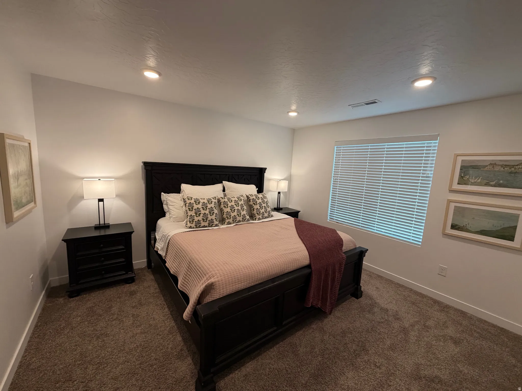 Carpeted bedroom with recessed lighting and a window featuring horizontal blinds