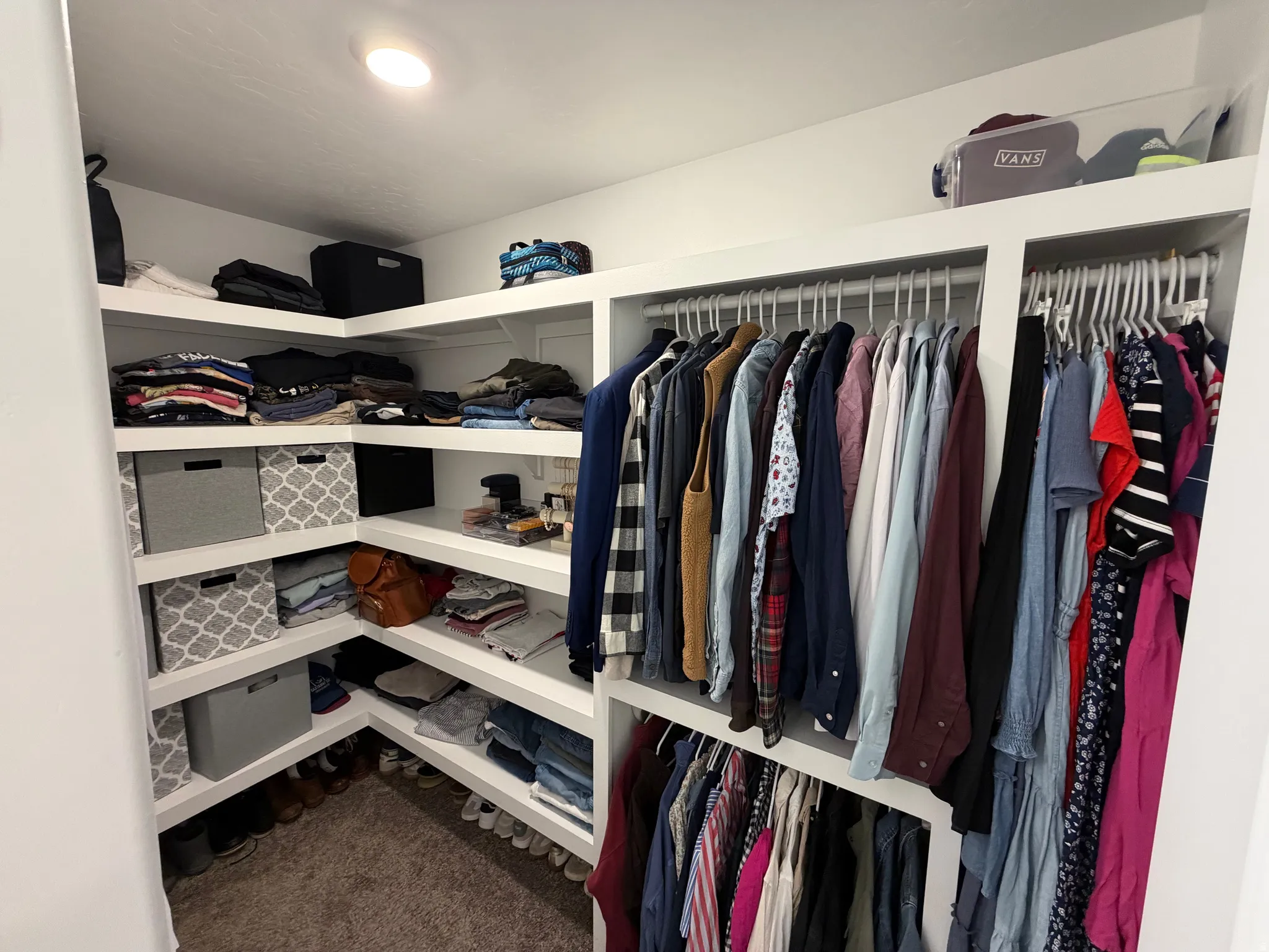 Custom closet system featuring white shelving and hanging rods