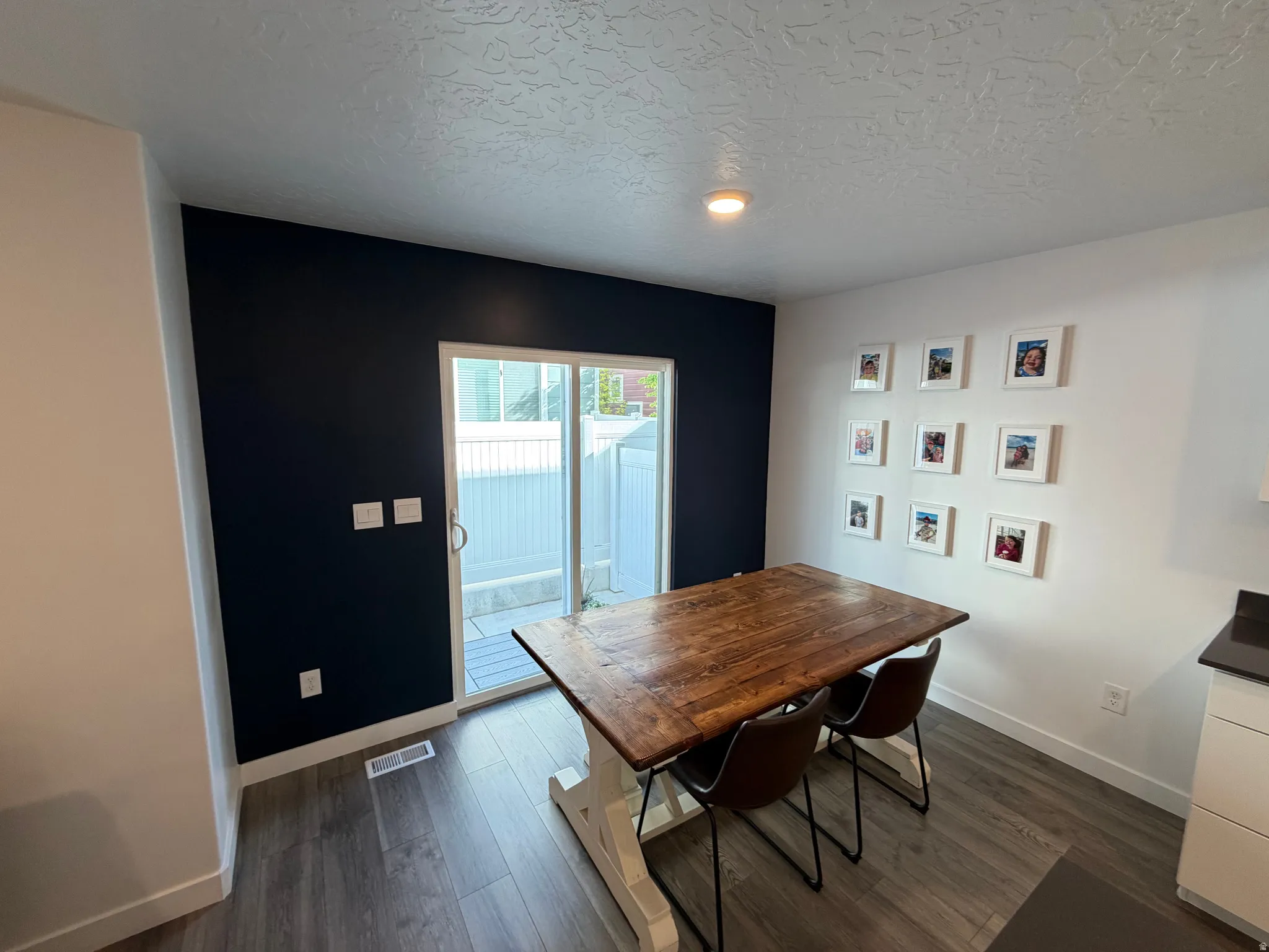Dining area featuring wood-finish flooring and a sliding glass door providing access to an outdoor patio