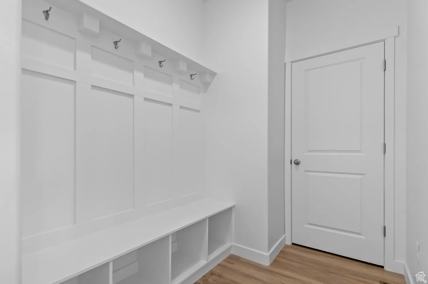 Built-in white board-and-batten storage unit featuring an integrated bench and open cubbies
