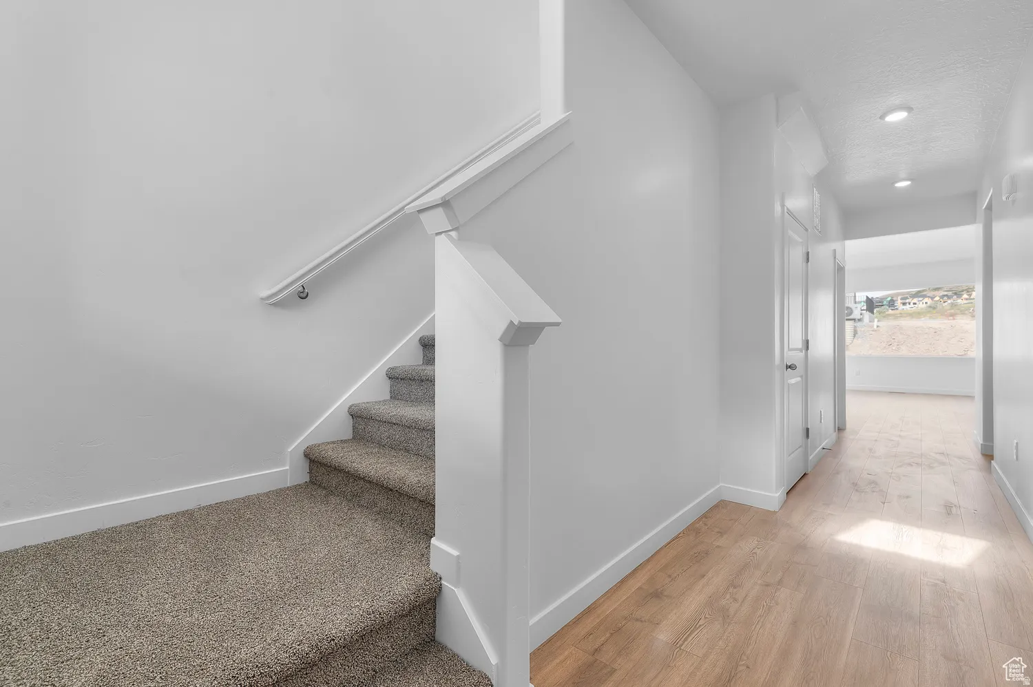 Carpeted staircase with white balustrade and handrail