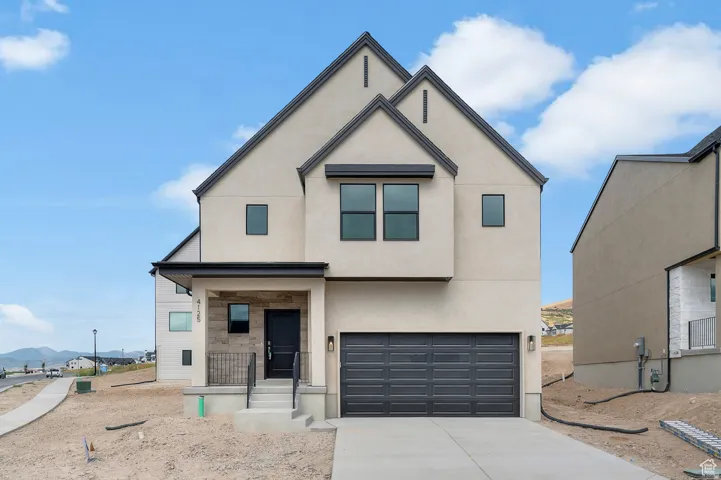 Contemporary two-story residence featuring a light-toned stucco exterior with dark trim accents