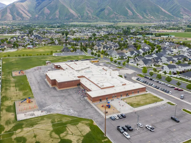 Aerial perspective showcasing a community with residential properties and a central school building