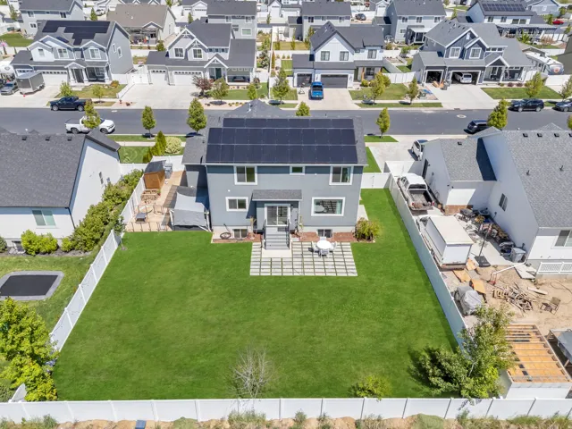 Expansive fenced backyard featuring a manicured lawn and a spacious paver patio