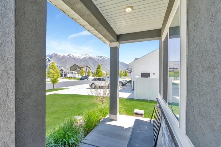 Covered porch with textured stucco exterior and vertical siding on the soffit