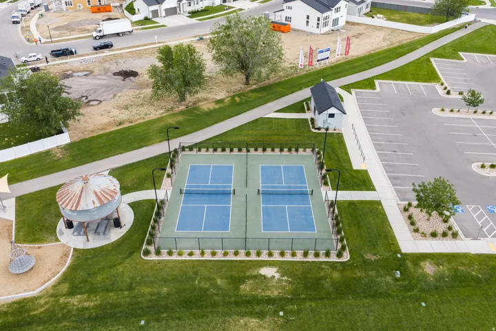 Dual pickleball courts with perimeter fencing and integrated lighting