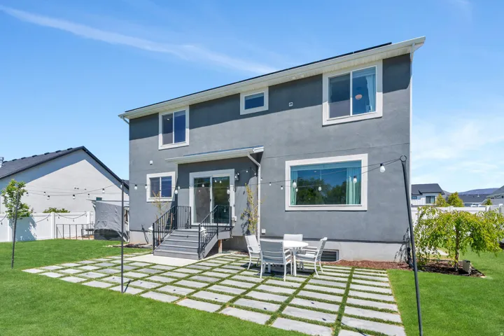 Spacious backyard featuring a large grass lawn and a concrete paver patio