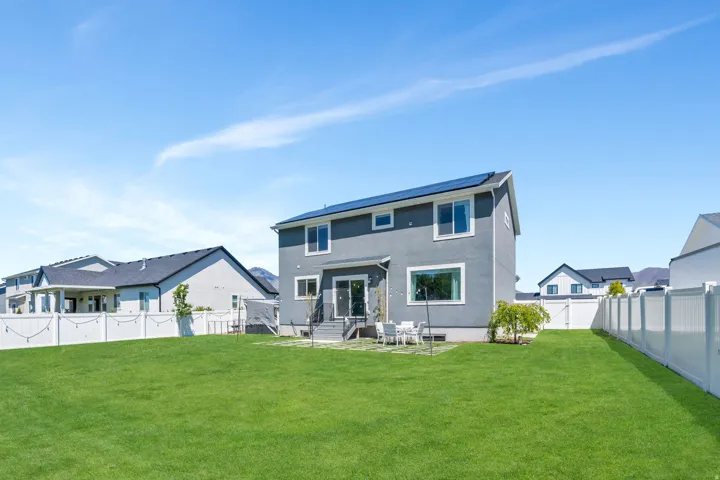 Expansive green lawn with a white vinyl privacy fence