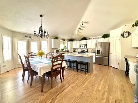 Open-concept kitchen and dining area featuring light wood-finish flooring