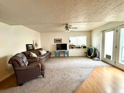 Spacious room featuring light-toned carpeting and a partial wood-finish floor