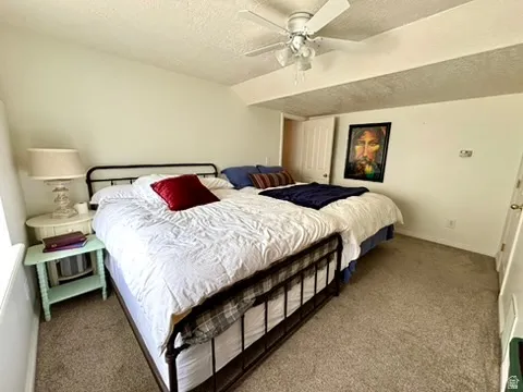 Carpeted room featuring a ceiling fan, vaulted ceiling, and white painted walls