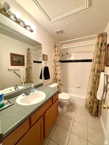 Bathroom featuring a single vanity with wood cabinetry, a large mirror, and overhead lighting