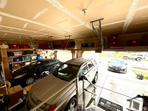 Spacious garage featuring a finished ceiling, built-in overhead storage racks, and an automatic garage door opener