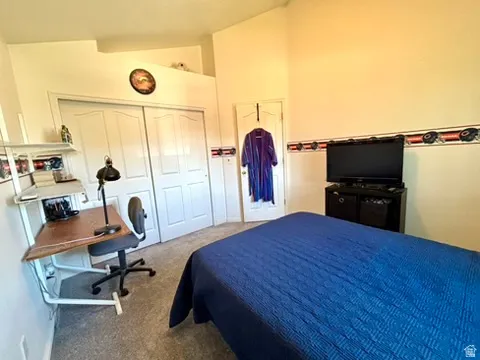 Carpeted room featuring a sloped ceiling and bi-fold closet doors