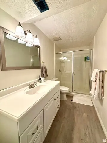 Bathroom featuring a white vanity with integrated sink, brushed nickel faucet, and framed mirror